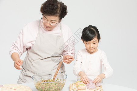 奶奶教孙女包饺子背景图片