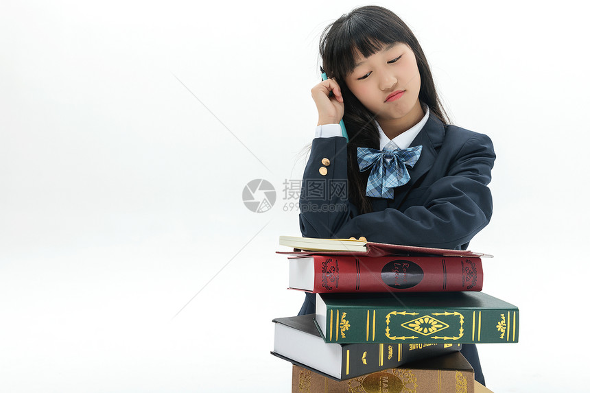 女学生靠着书本写作业图片