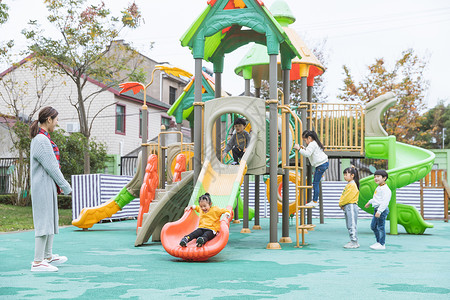 带孩子春游的老师户外幼师带儿童玩滑滑梯背景