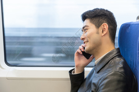 男性在车厢座位打电话高清图片
