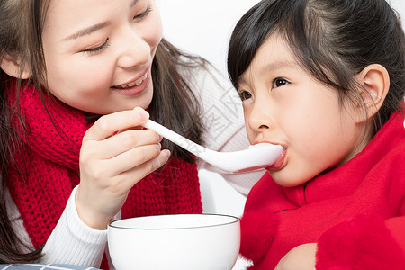 吃汤圆的孩子妈妈喂女儿吃汤圆背景