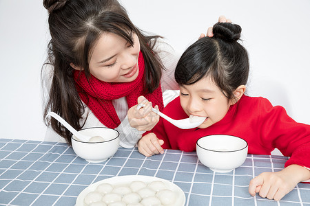 冬至节气女孩与汤圆插画妈妈喂女儿吃汤圆背景