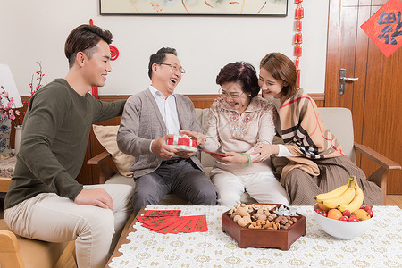 春节家人团圆孩子送父母礼物高清图片