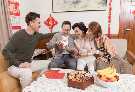 春节一家人团圆孩子送父母礼物背景图片