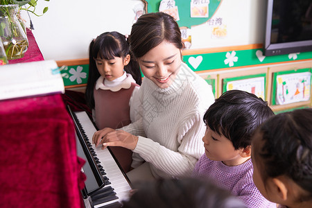 钢琴教师幼儿园老师带小朋友弹钢琴背景