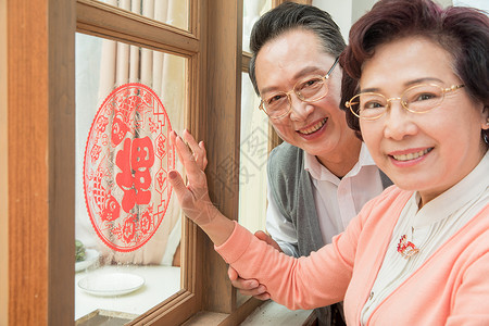 老年夫妇贴窗花背景图片