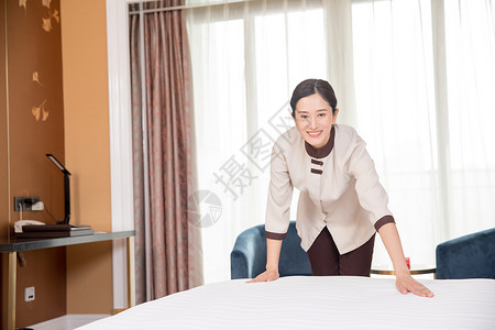 酒店客房整理床铺背景图片