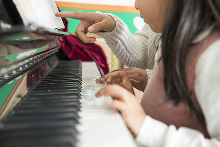 钢琴小孩素材幼儿园老师教弹钢琴背景