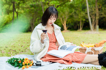 女生喝酒素材女性户外野餐阅读背景