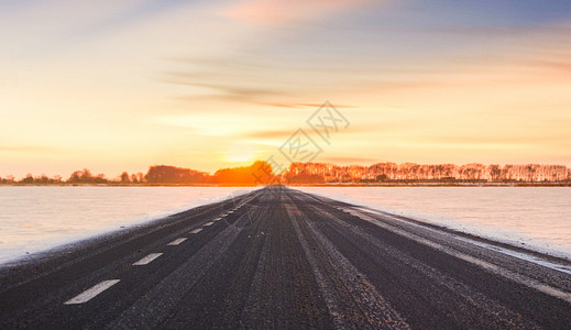 冬天日出雪地公路设计图片