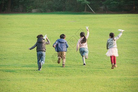 冬天的草坪玩纸飞机的孩子们背景