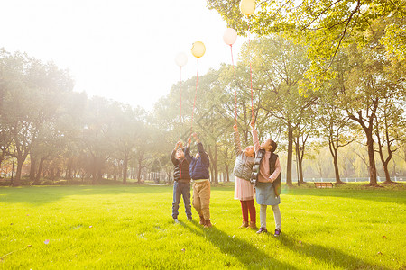 阳光下快乐儿童们拿气球图片