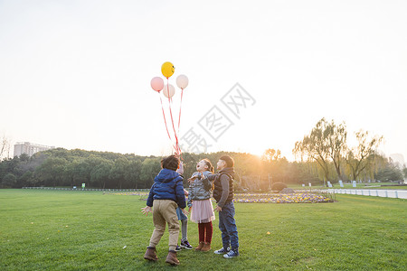 共同成长夕阳下儿童们共同放气球背景