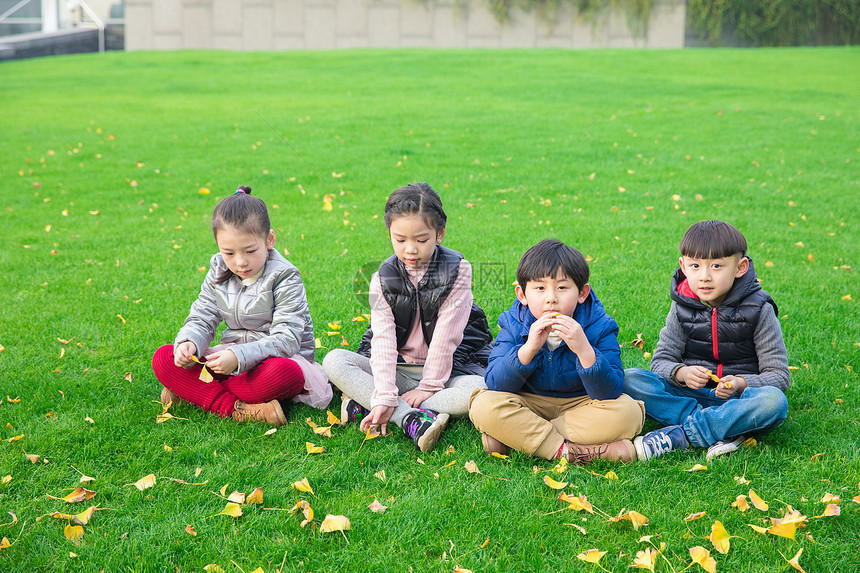 儿童坐在草坪上玩耍图片