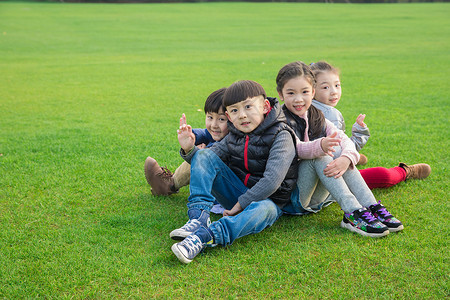 儿童坐在草坪上玩耍图片