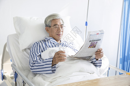 老年病人病床看报纸背景图片