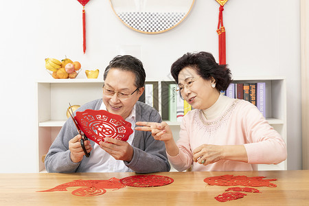 奶奶教爷爷剪窗花背景图片