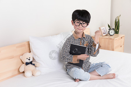 小朋友在看书在床上看书的小男孩背景