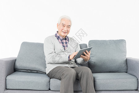 老人在沙发上看平板电脑图片