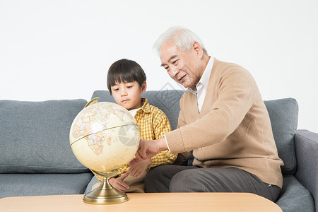 祖孙在沙发上看地球仪图片