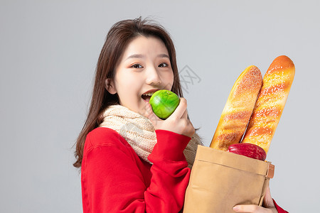 购物女生吃水果形象背景图片