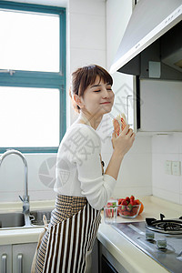 厨房里吃三明治的女性背景图片