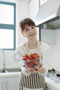 厨房里吃草莓的女性背景图片