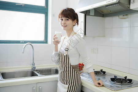 厨房里喝牛奶的女性图片