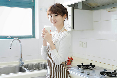 厨房里喝牛奶的女性高清图片