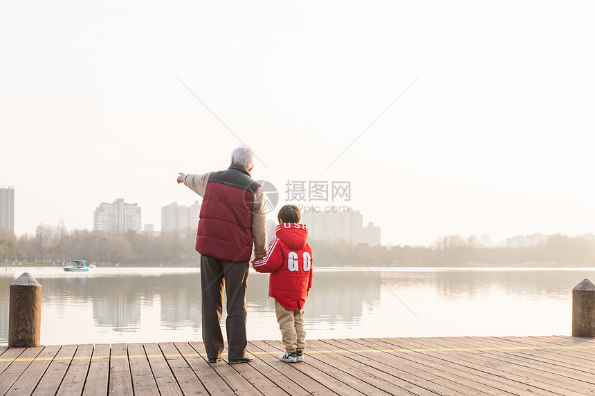 祖孙情夕阳下爷爷牵孙子背影图片