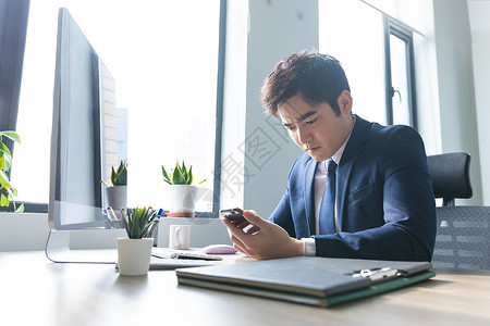 商务男士办公室查看手机图片