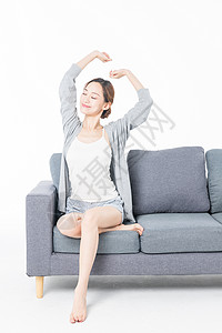 年轻女性沙发上伸展高清图片