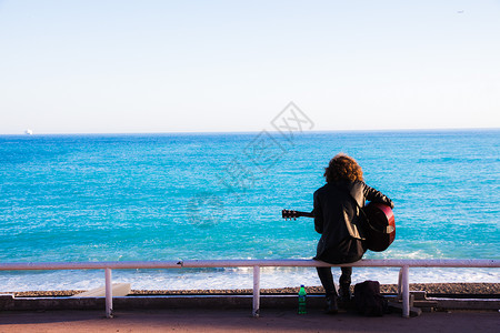 海边弹吉他的人背景图片