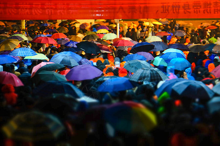 潮妆下雨天中超比赛散场人群背景