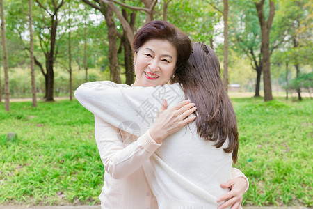 互相依偎公园互相拥抱的母女背景