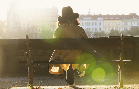 坐在布拉格伏尔塔瓦河边的女子背影图片