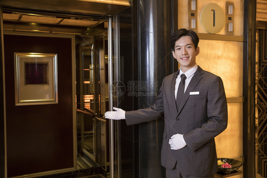 酒店服务员为顾客开电梯图片