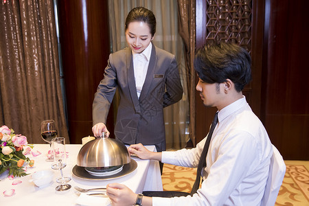 酒店服务员给顾客打开餐盖高清图片