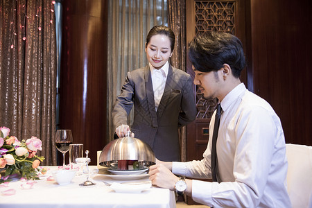 酒店服务员给顾客打开餐盖服务生高清图片素材