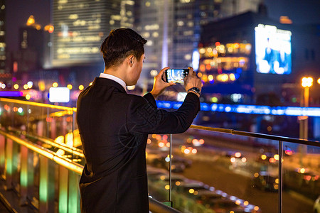 年轻商务男子天桥玩手机背景