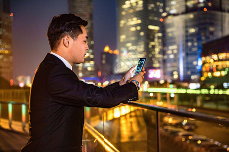 年轻商务男子天桥玩手机背景