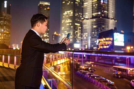 年轻商务男子天桥玩手机图片