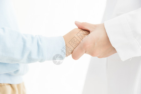 医患互动医生和儿童握手特写背景