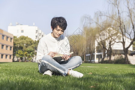 男性在草坪上阅读图片