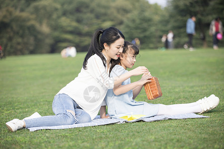 女儿和妈妈草地上玩耍背景图片