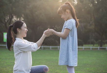 女儿和妈妈草地上玩耍高清图片