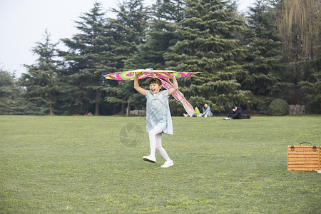 春天的风筝小女孩拿着风筝在草坪上奔跑背景