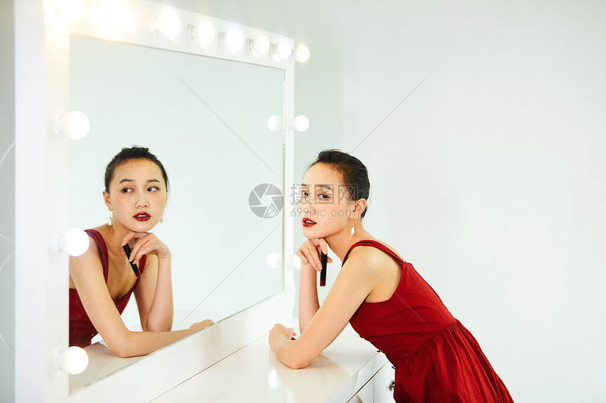 性感美女在化妆镜前涂口红图片