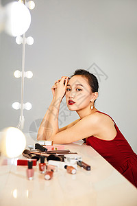涂红性感美女在化妆镜前涂口红背景
