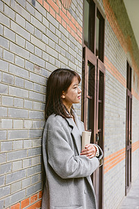 倚靠走廊看书的女孩背景图片